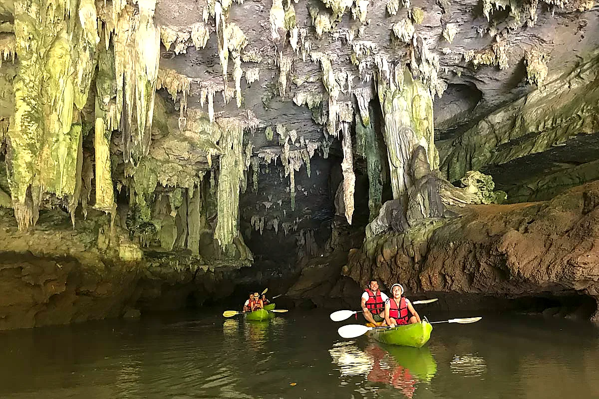 Kayakers paddling into a limestone cave