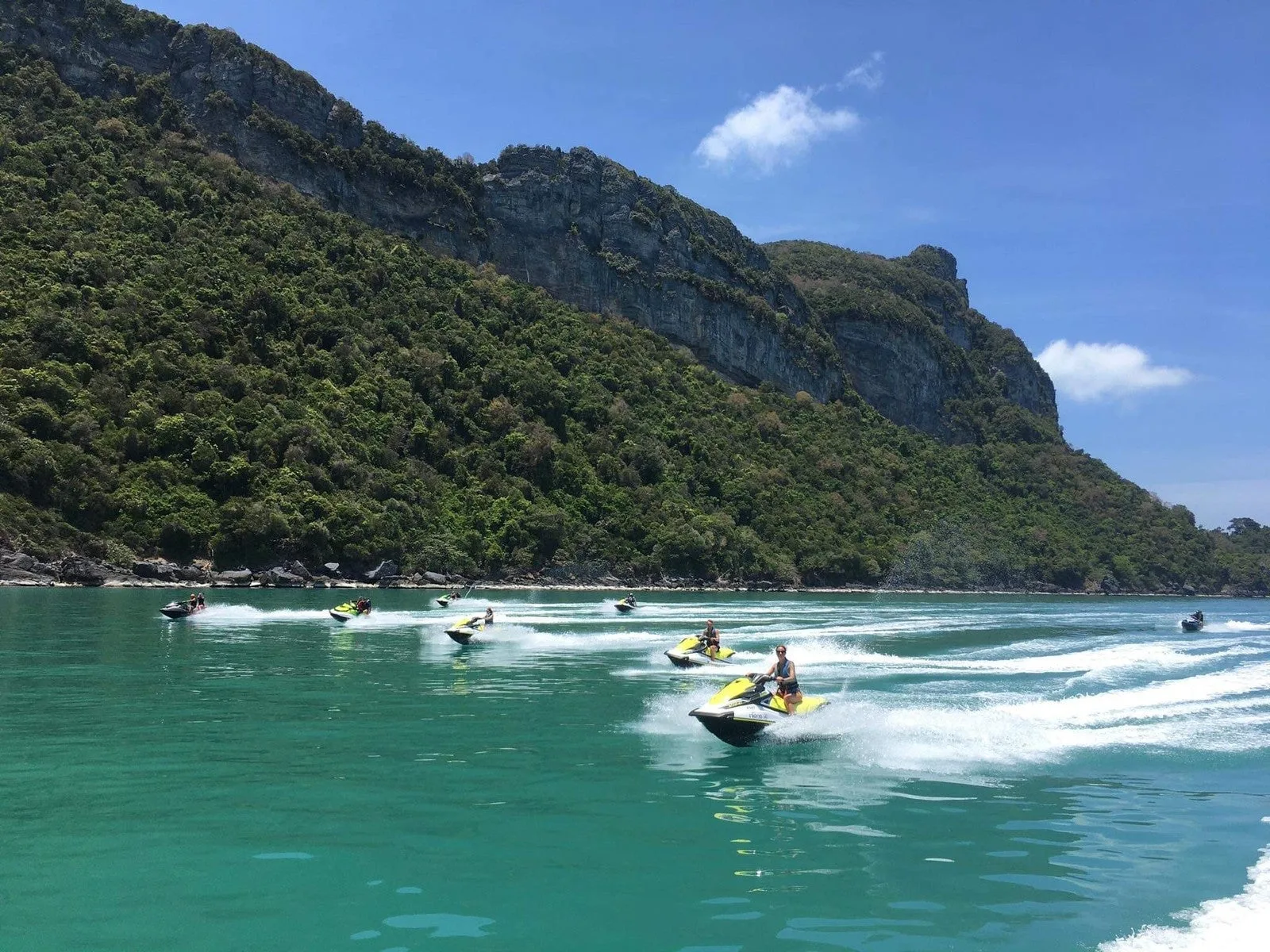 Pacchetto sport acquatici 1 a Koh Samui – gruppo in safari in moto d'acqua che passa davanti a scogliere verdi