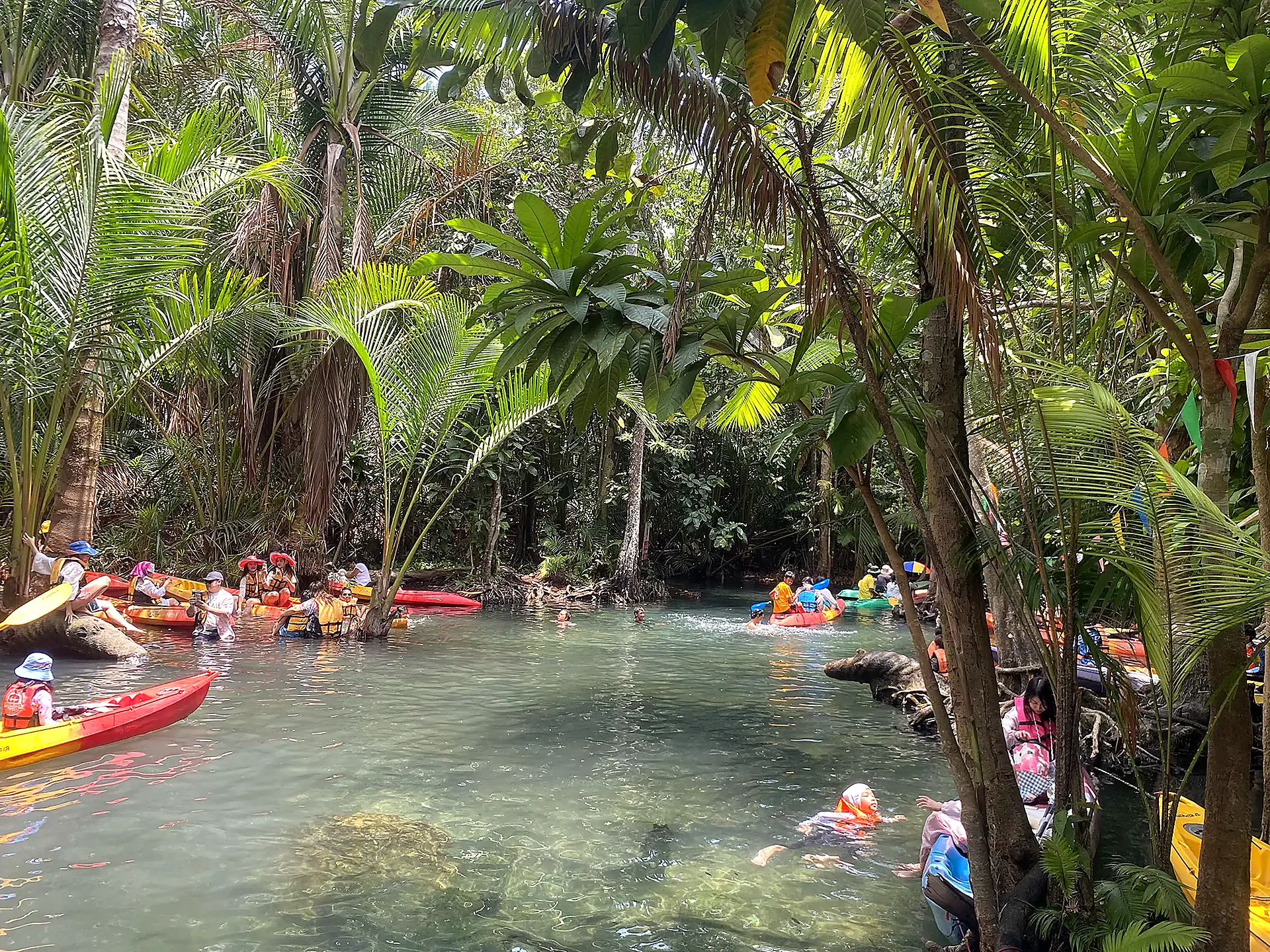 Kayakers on a clear jungle river lagoon
