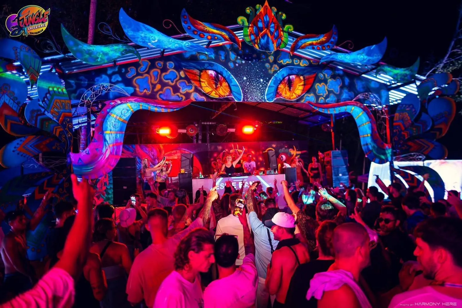Jungle Experience Party Koh Phangan – arched stage with glowing eyes and the crowd with hands up