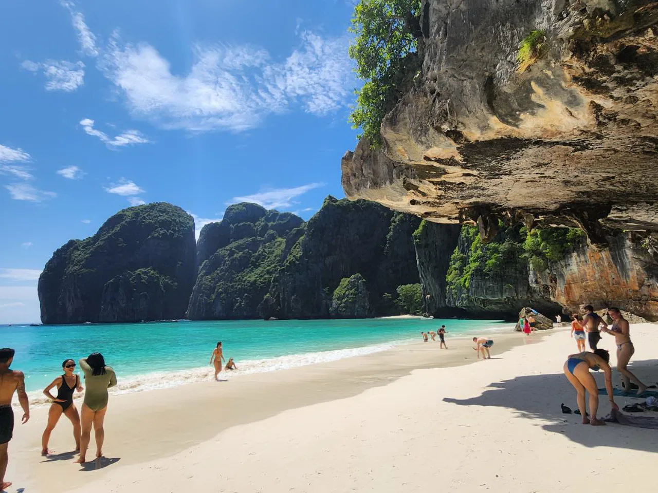 Visitors on the beach under the cliffs at Maya Bay