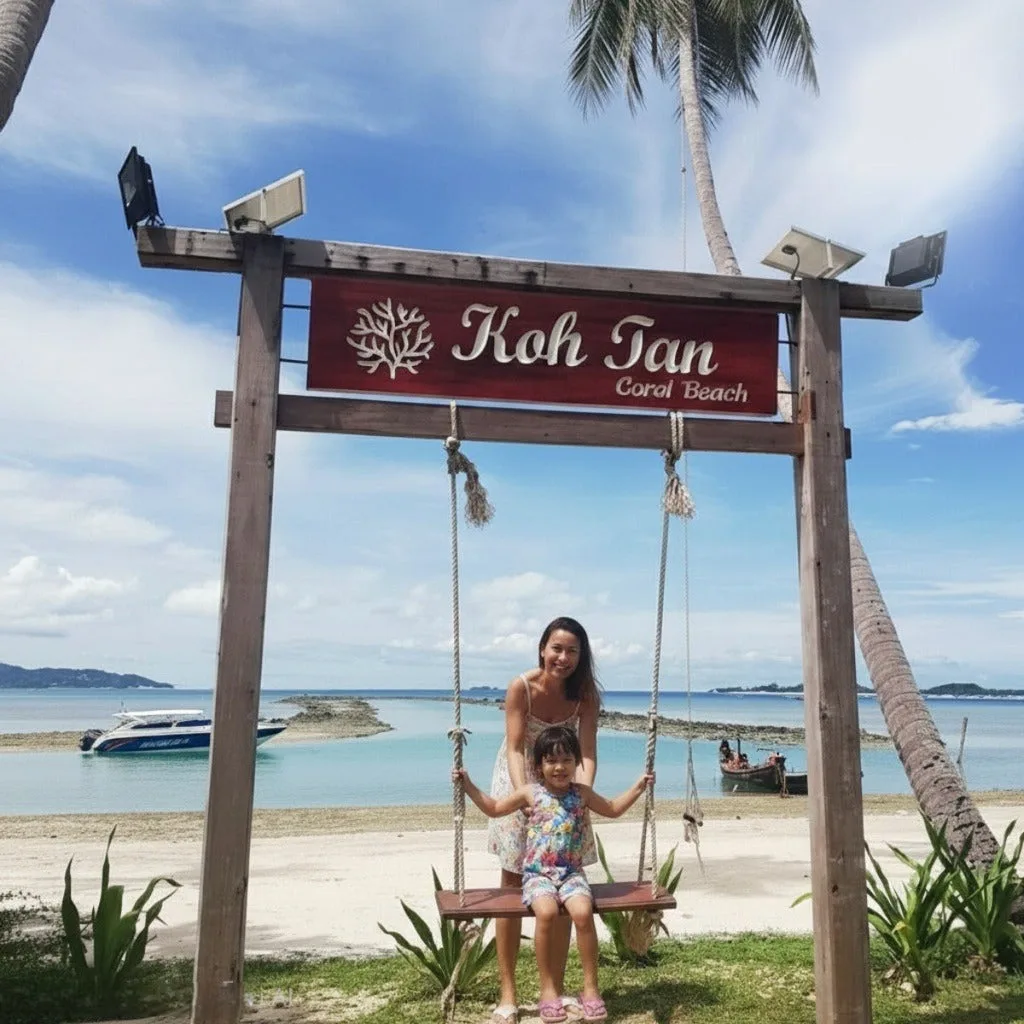 Мать и дочь на качелях под табличкой Koh Tan Coral Beach, остановка для снорклинга на Самуи