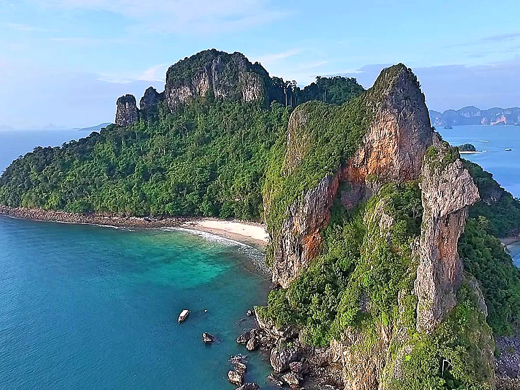 Green limestone island rising from the Andaman Sea